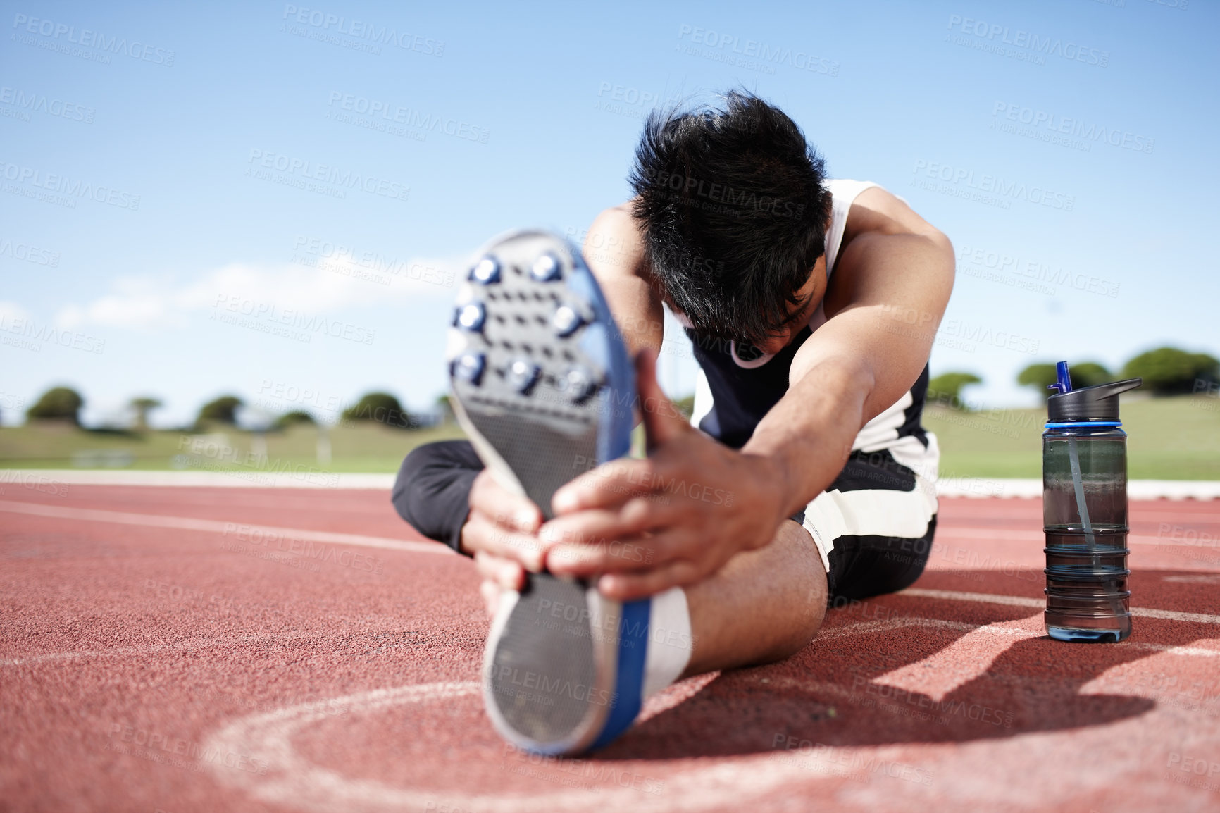 Buy stock photo Man, foot and stretching legs on running track, warm up and preparation for exercise or workout. Male person, start and outdoor for fitness with water bottle, athlete and ready for marathon training