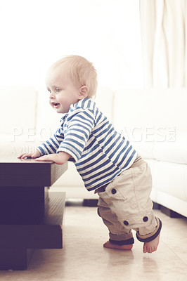 Buy stock photo A cute baby boy trying to standing while at home