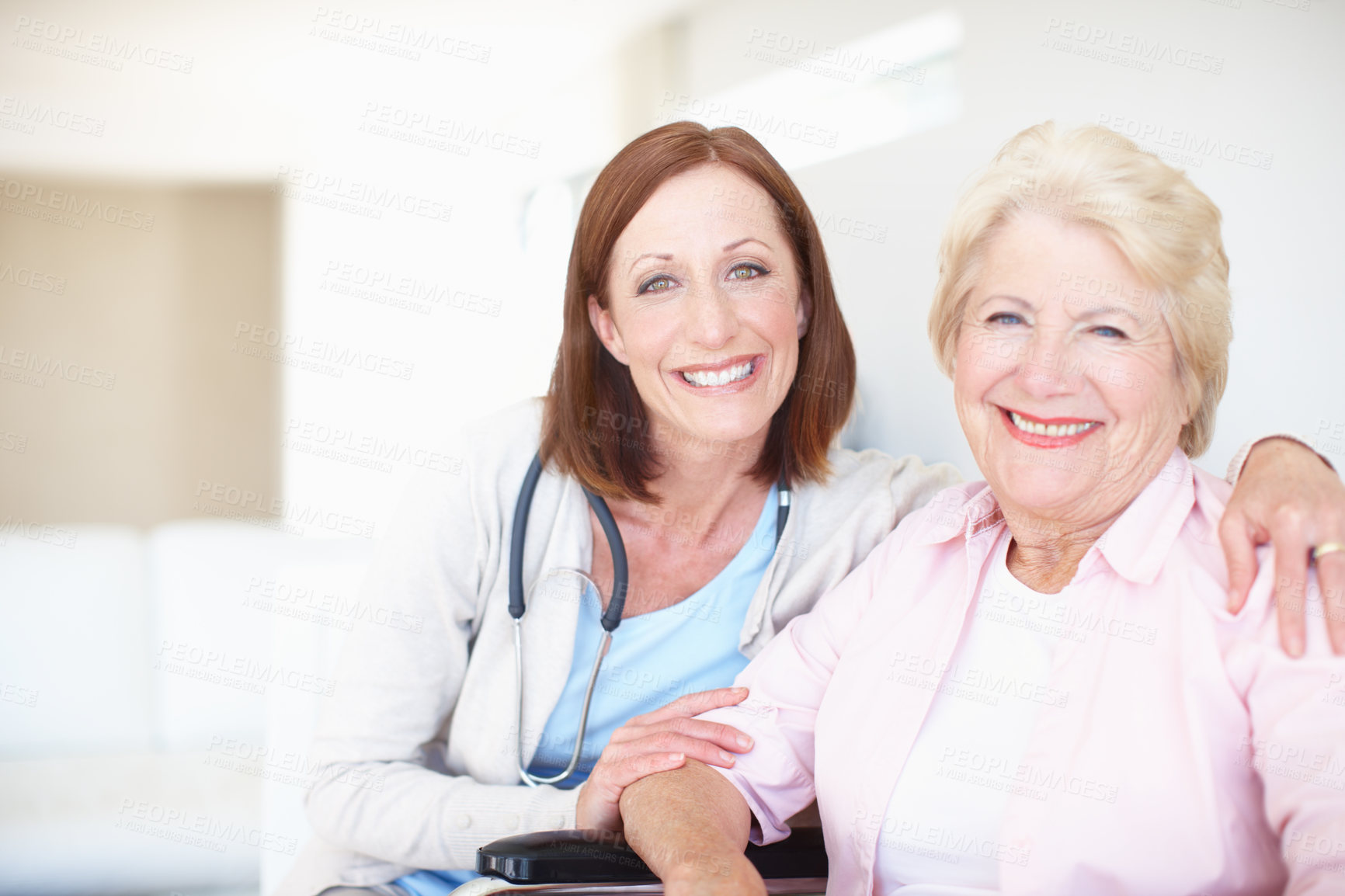 Buy stock photo Smiling mature nurse embraces her delighted elderly female patient 