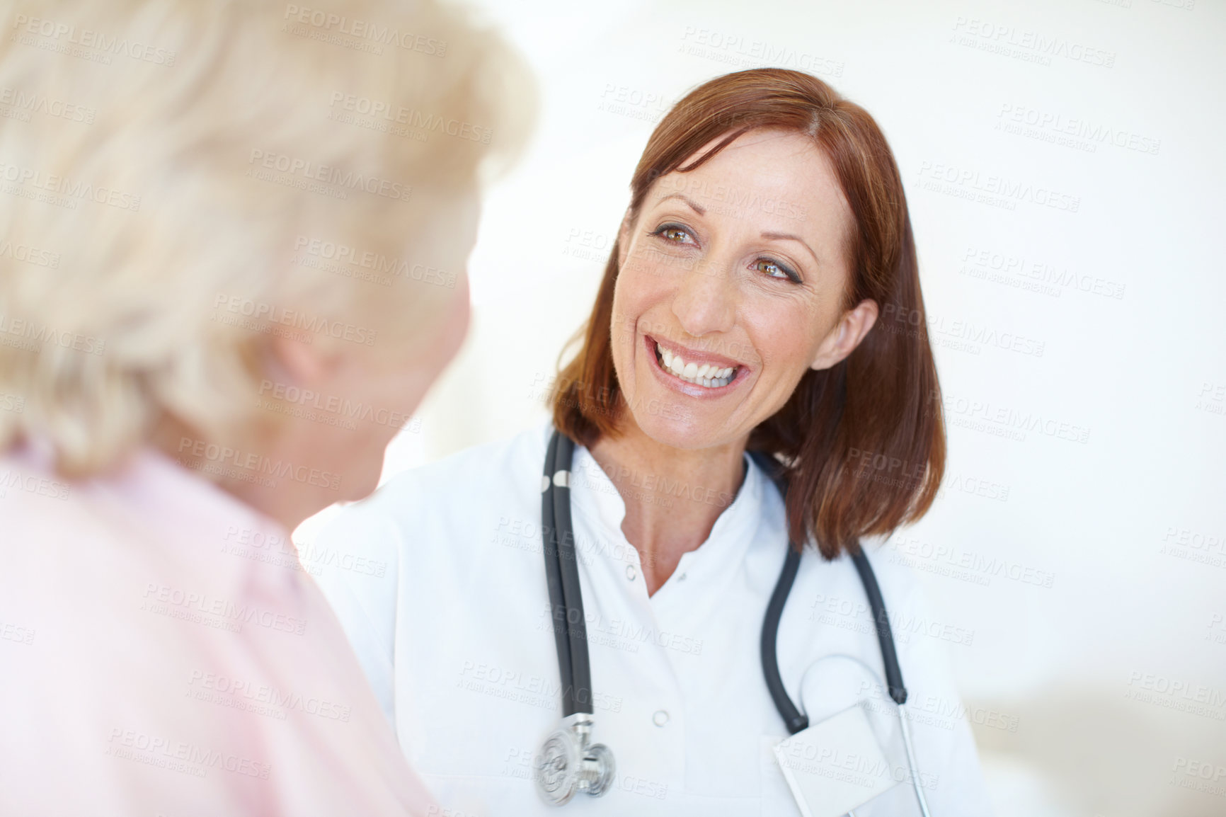 Buy stock photo Friendly mature nurse visits her elderly female patient with a smile