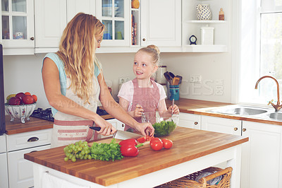 Buy stock photo Mother, child and vegetables for salad in kitchen with cutting ingredients, meal prep and teaching healthy vegan recipe. Woman, girl and learning to cook with support, helping hand or bonding in home