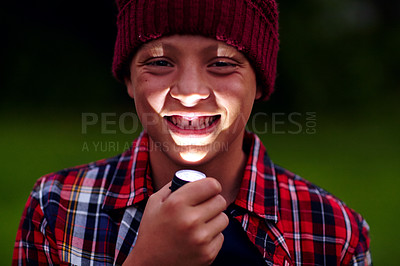 Buy stock photo Cropped portrai of a little boy holding a flashlight under his chin