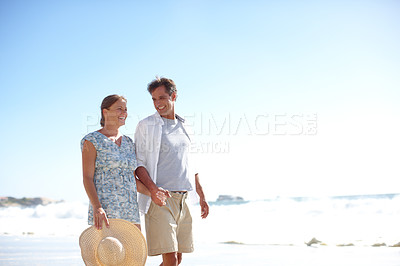 Buy stock photo A happy mature couple walking together on the beach