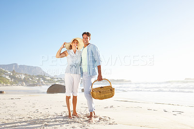 Buy stock photo A loving mature couple enjoying a walk on the beach together