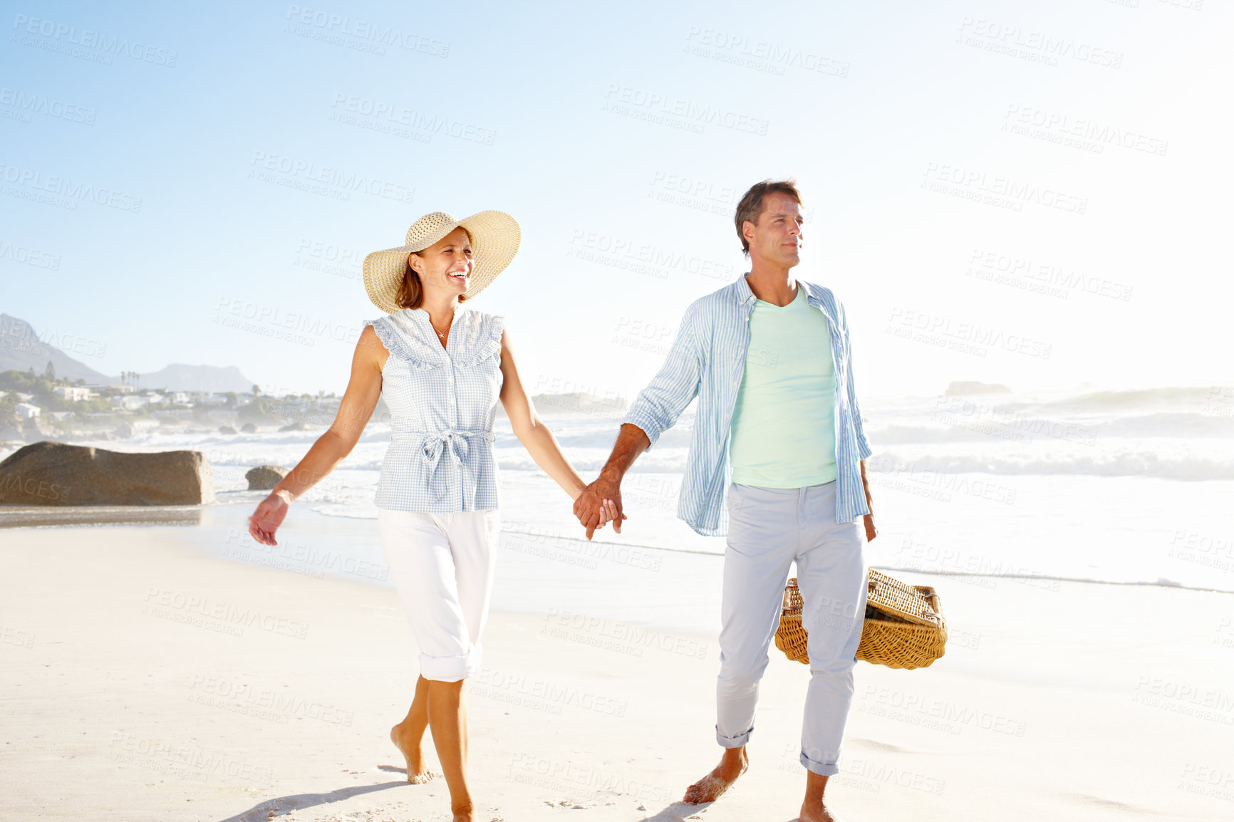 Buy stock photo Holding hands, beach and mature couple with picnic, basket and love for summer vacation in Miami. Man, woman and smile with sea, holiday and bonding for relationship anniversary or weekend by ocean