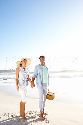 Buy stock photo A blissful couple enjoying a beautiful day on the beach together