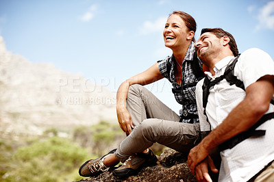 Buy stock photo Two hikers laughing and smiling while enjoying a mountain top view