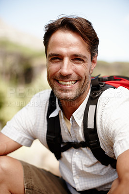 Buy stock photo Handsome male hiker smiling while seated on a mountain top