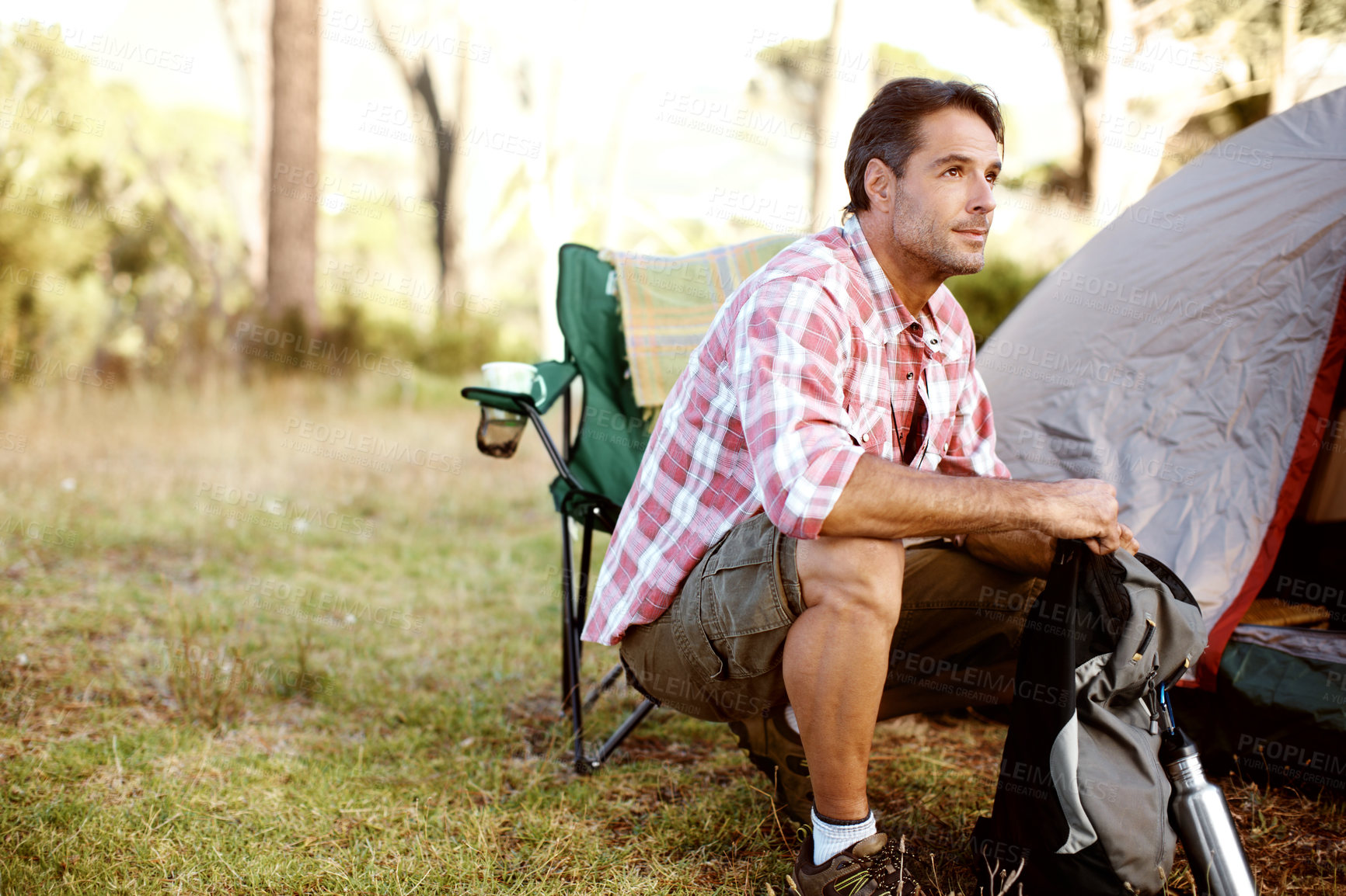 Buy stock photo Man, thinking and camping chair by tent, outdoor and perspective on adventure, journey or holiday in summer. Person, relax and remember on grass field for vacation, sunshine and nature in Argentina