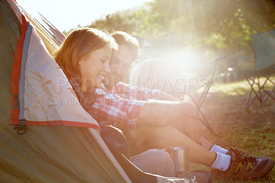 Buy stock photo A young couple sitting at the entrance of their tent