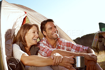 Buy stock photo A happy couple sitting at the entrance of their tent