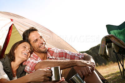 Buy stock photo A happy couple admiring nature while sitting by their tent