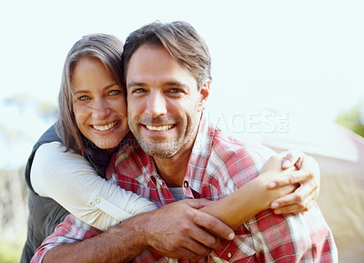 Buy stock photo A young couple smiling with a tent in the background