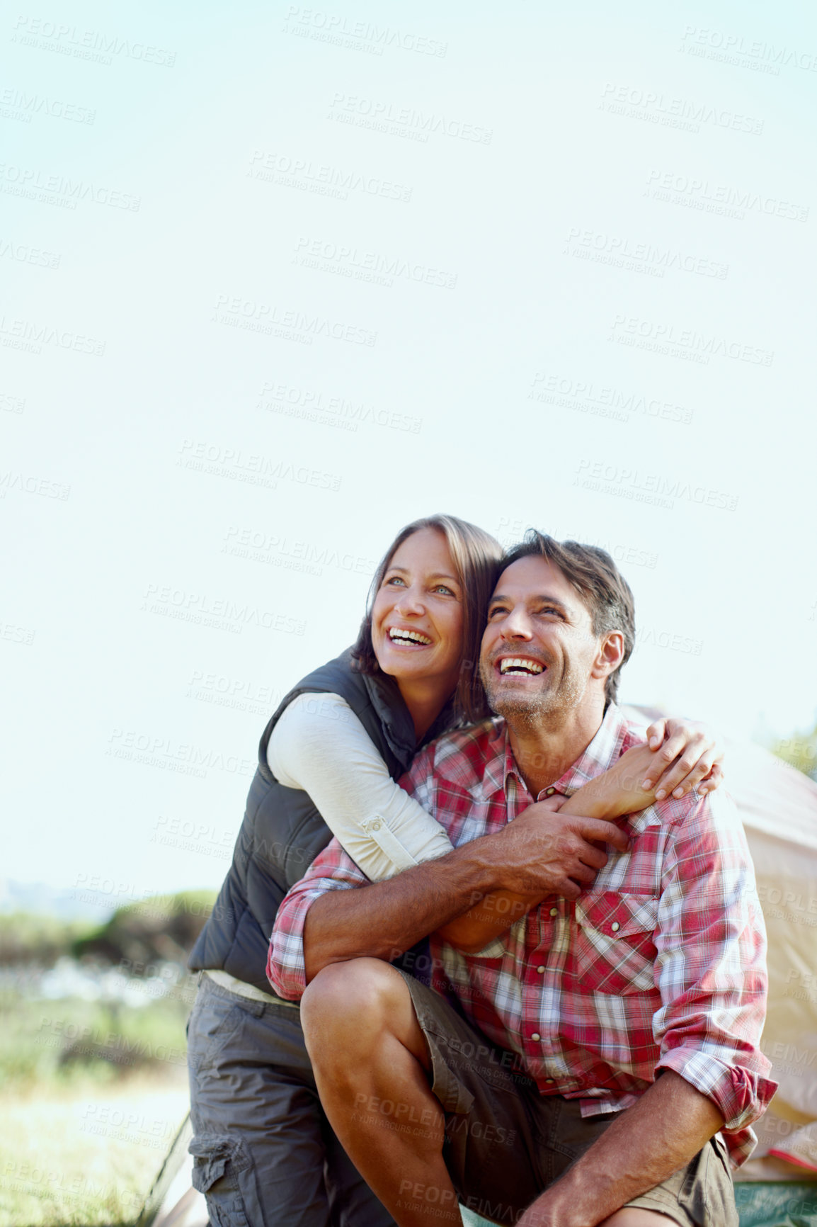 Buy stock photo A young couple camping outside and laughing