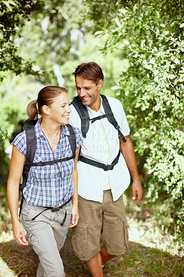 Buy stock photo Walking, hiking or happy couple in nature for travel, outdoor adventure or journey on path in woods. Love, smile or people in forest to relax together for holiday vacation or trekking to explore park