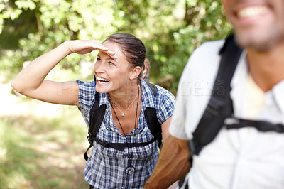 Buy stock photo A young woman walking with her husband while shading her eyes with her hand