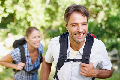 Buy stock photo A young couple standing outside with their backpacks on