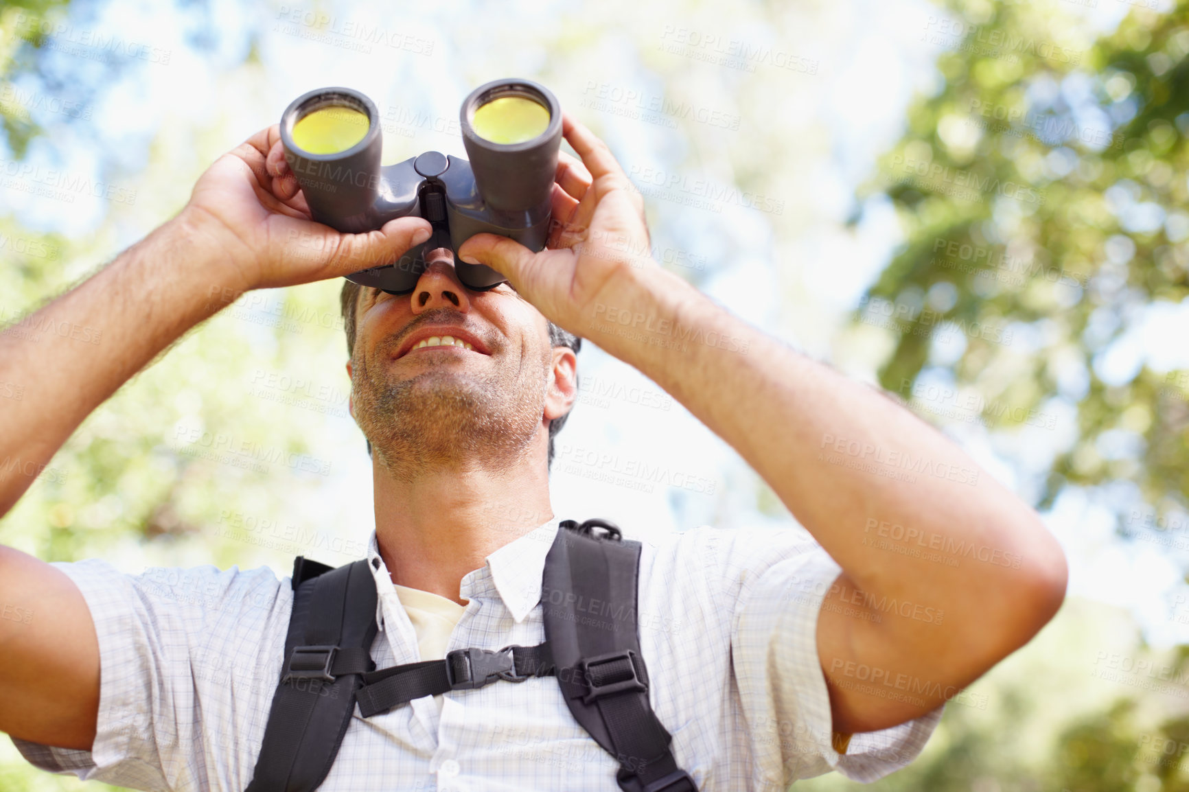 Buy stock photo Man, binoculars and travel to forest for hiking, tourist adventure and gear for nature discovery. Male person, countryside and glasses for bird watching or sightseeing, lens and explore wilderness