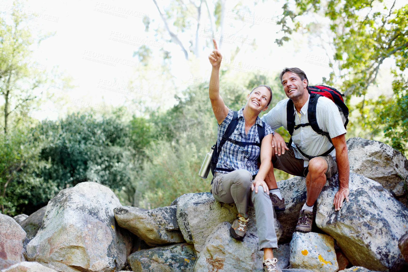 Buy stock photo Couple, pointing and happy in nature for hiking, fitness and adventure with bonding, view and support. Man, woman and rock outdoor for exercise, health and trekking with journey, travel and explore