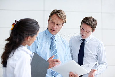 Buy stock photo Serious business executives going through documents together in an informal meeting 