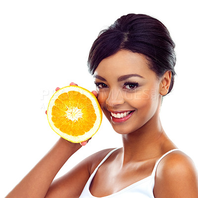 Buy stock photo A young woman in gymwear holding an orange and smiling at the camera