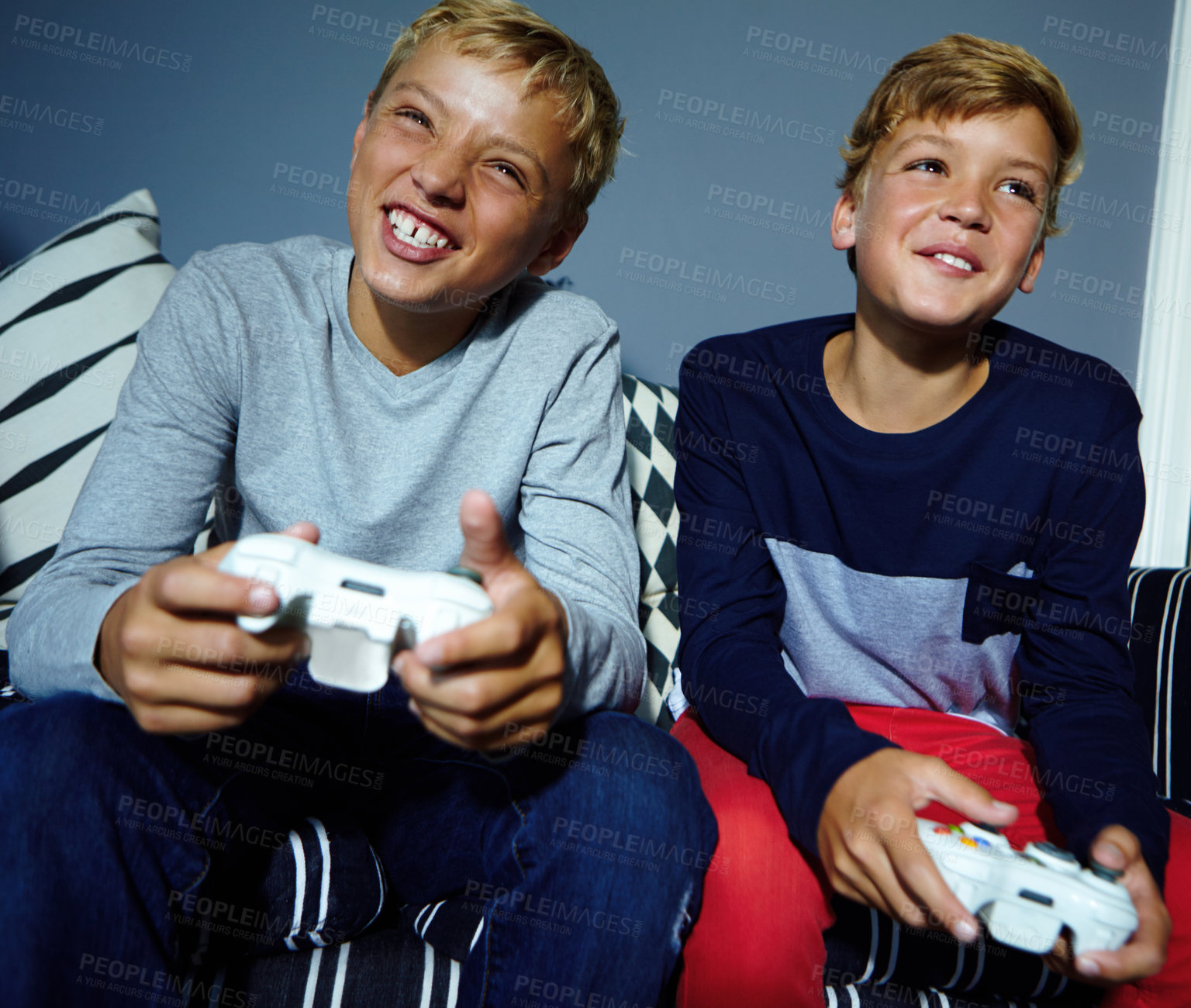 Buy stock photo Shot of young boys playing video games