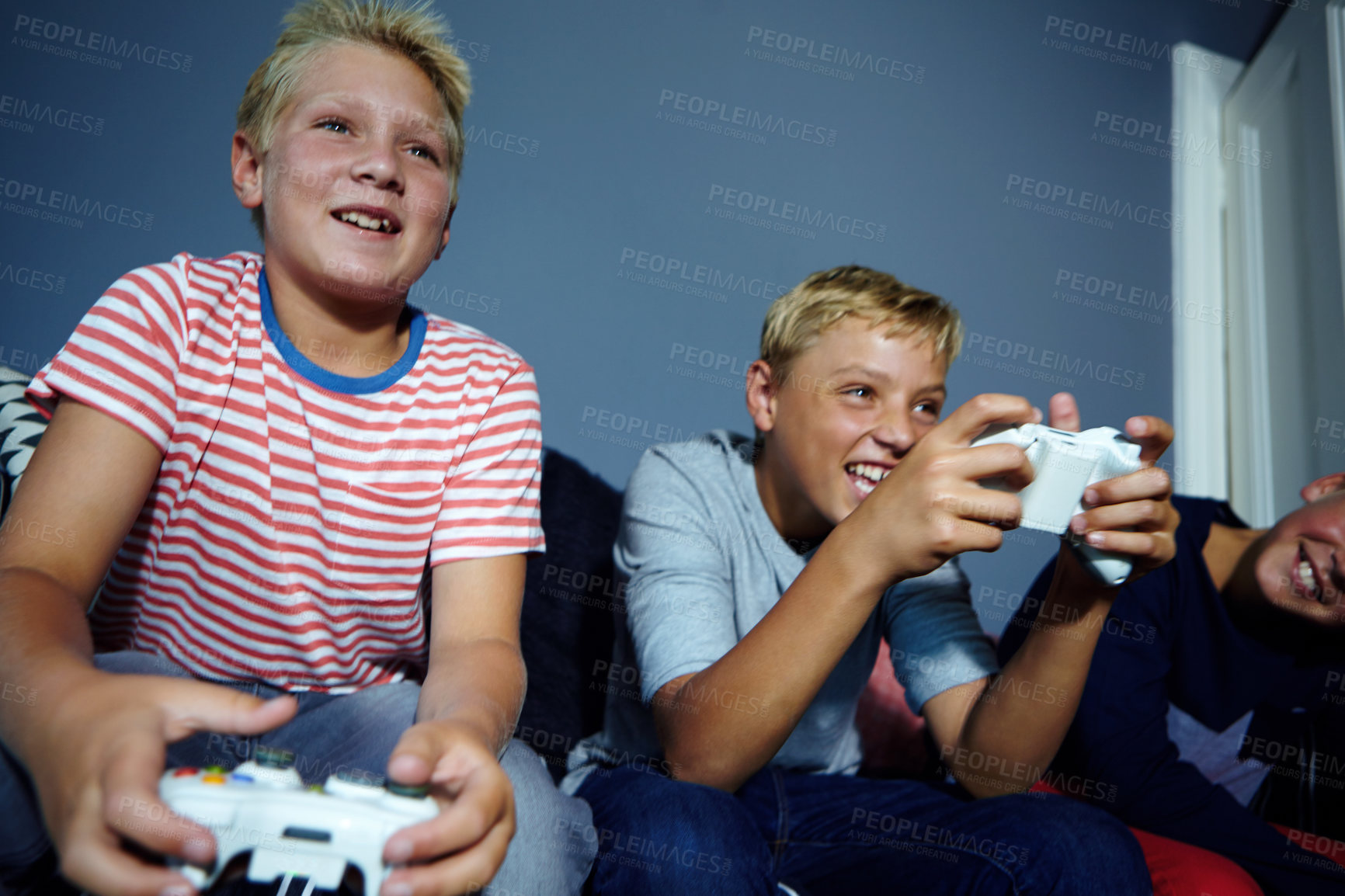 Buy stock photo Shot of young boys playing video games