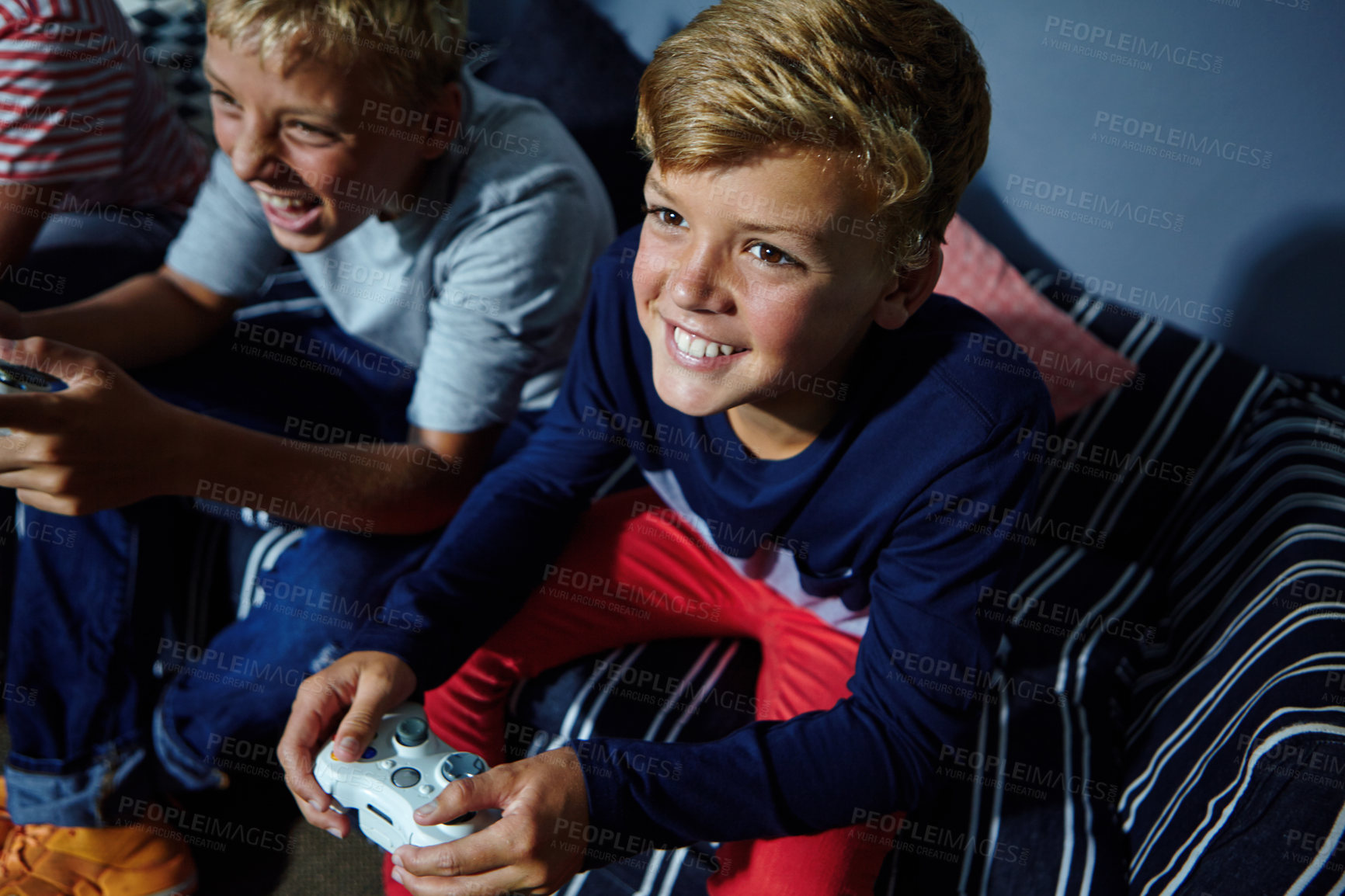 Buy stock photo Shot of young boys playing video games