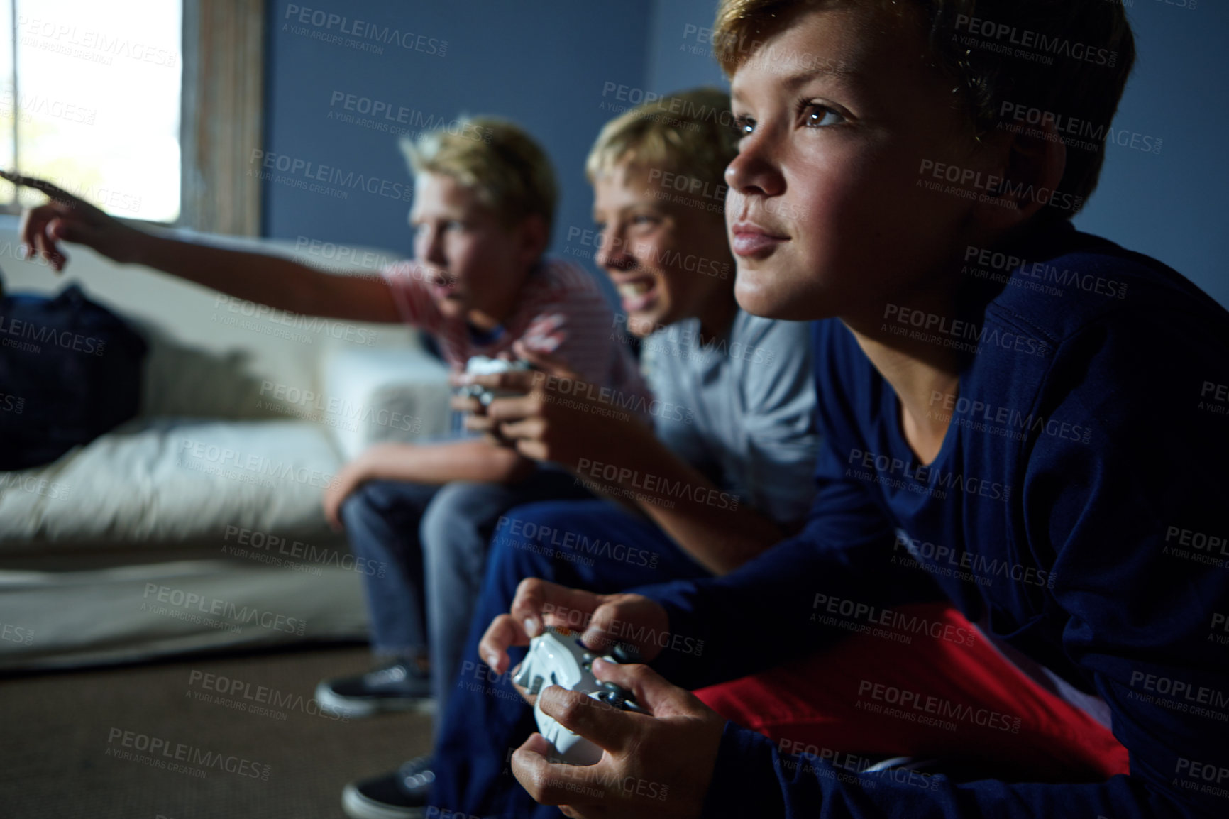 Buy stock photo Shot of young boys playing video games