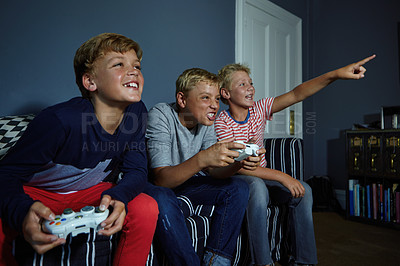 Buy stock photo Shot of young boys playing video games