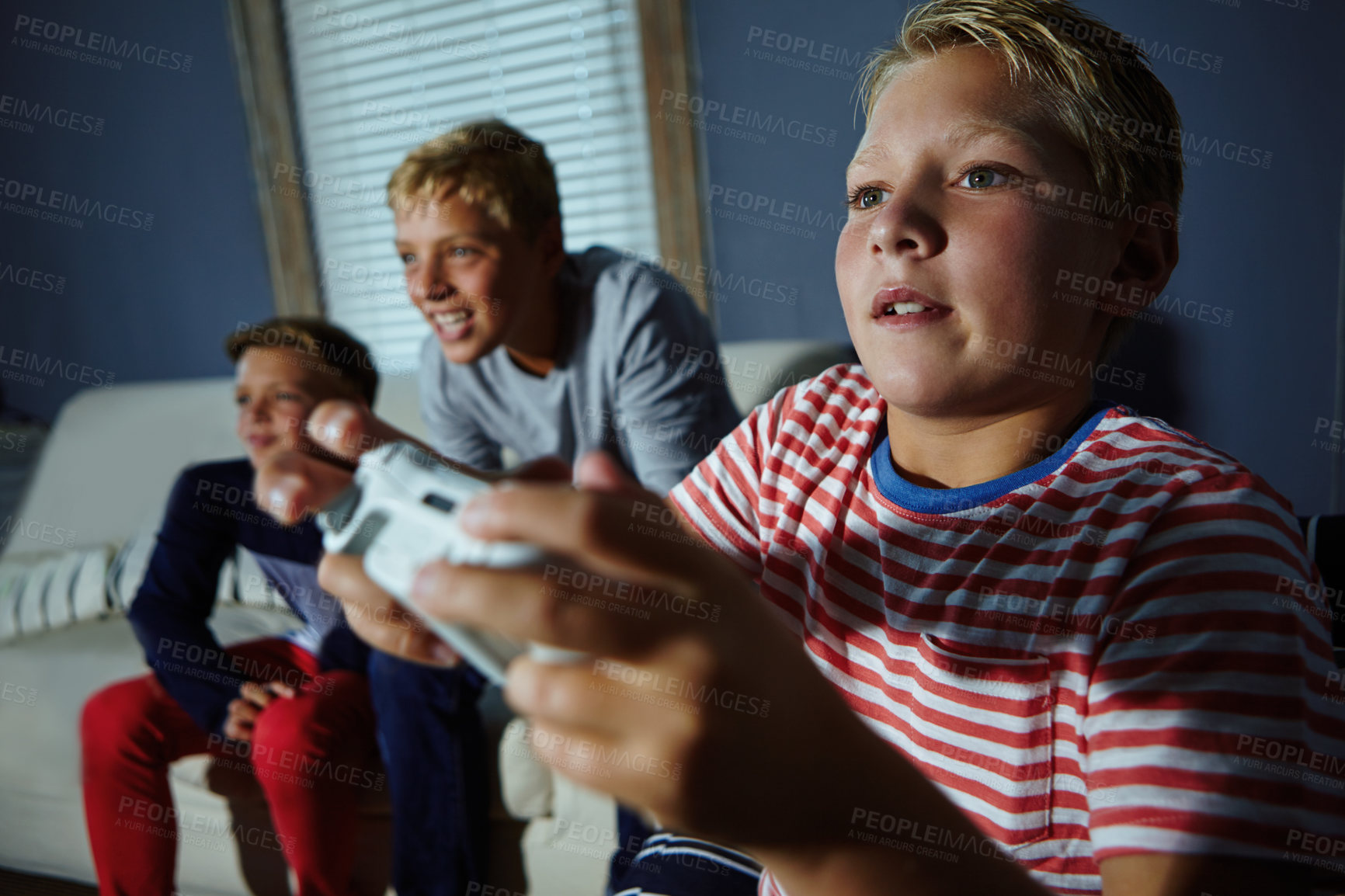 Buy stock photo Shot of young boys playing video games