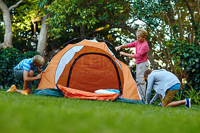 Buy stock photo Shot of three young boys putting up their tent