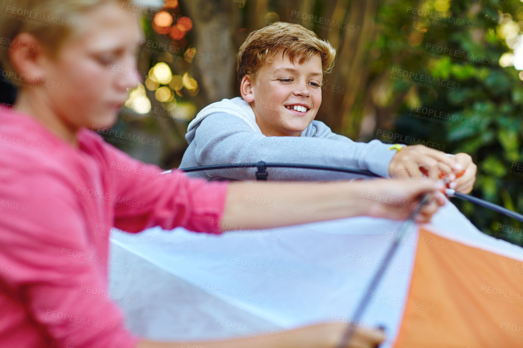 Buy stock photo Shot of two young boys putting up their tent