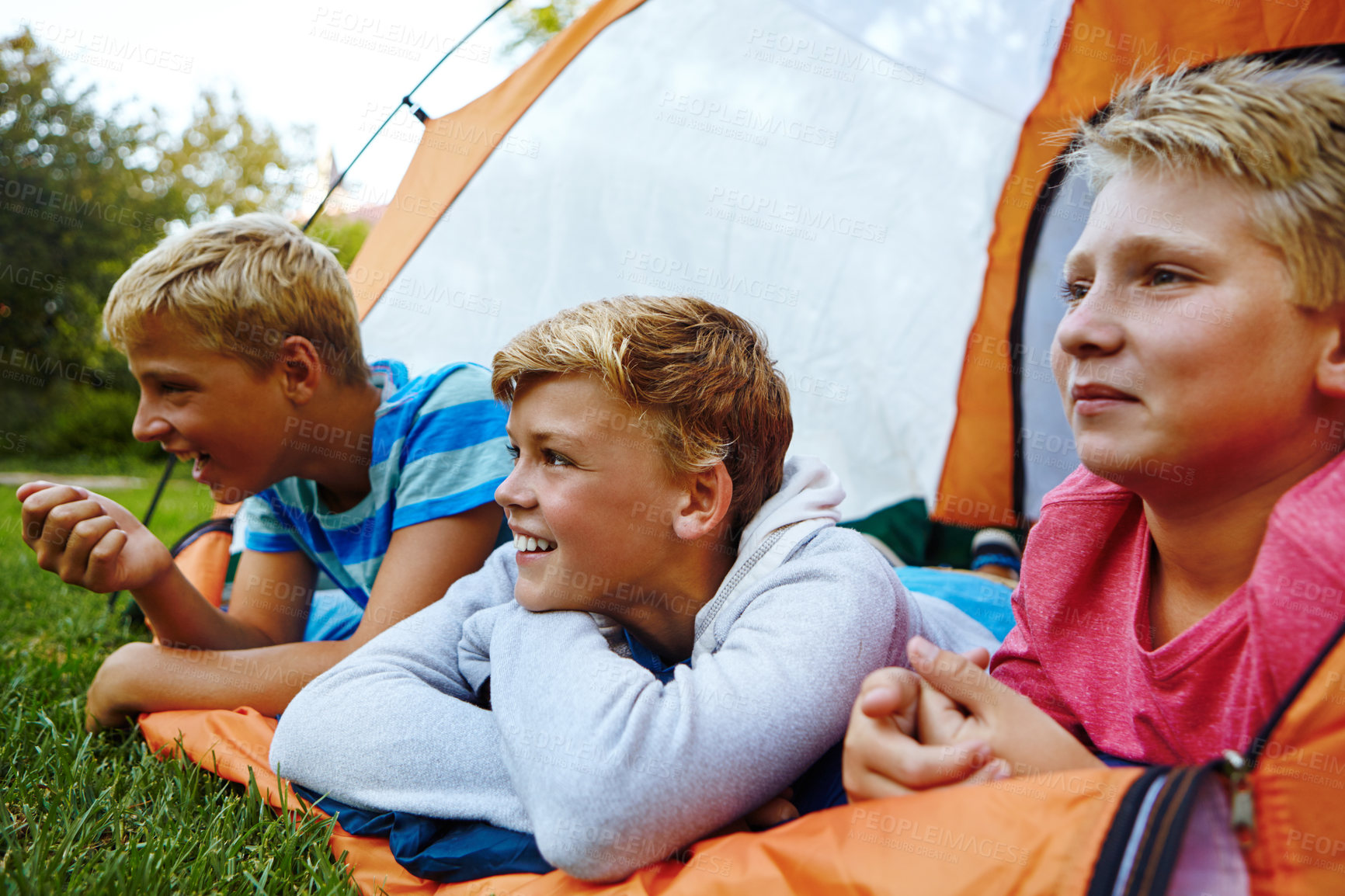 Buy stock photo Cropped shot of three young boys lying in their tent