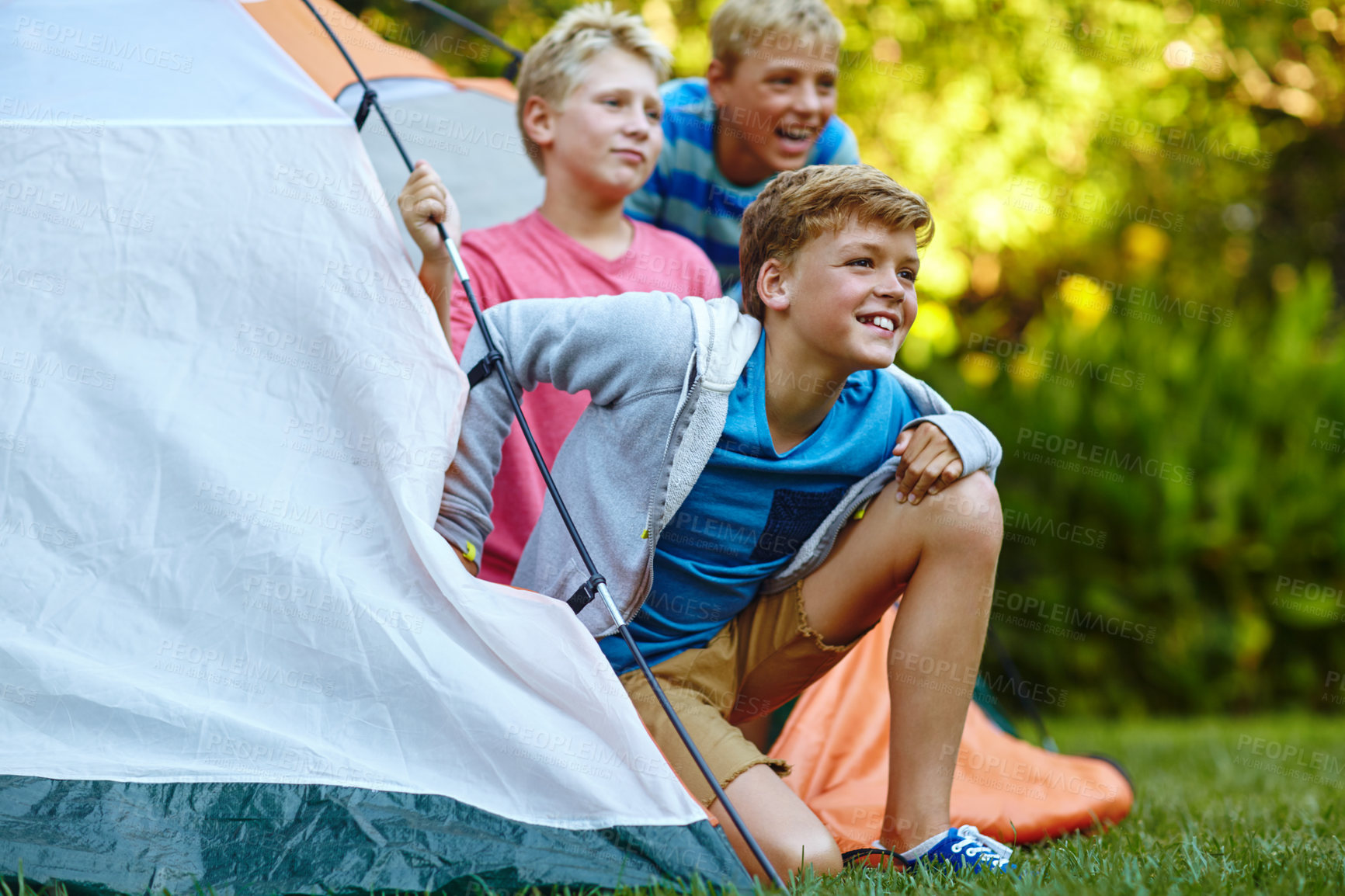 Buy stock photo Cropped shot of three young boys looking out of their tent