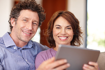 Buy stock photo Shot of a couple using a tablet  while relaxing at home