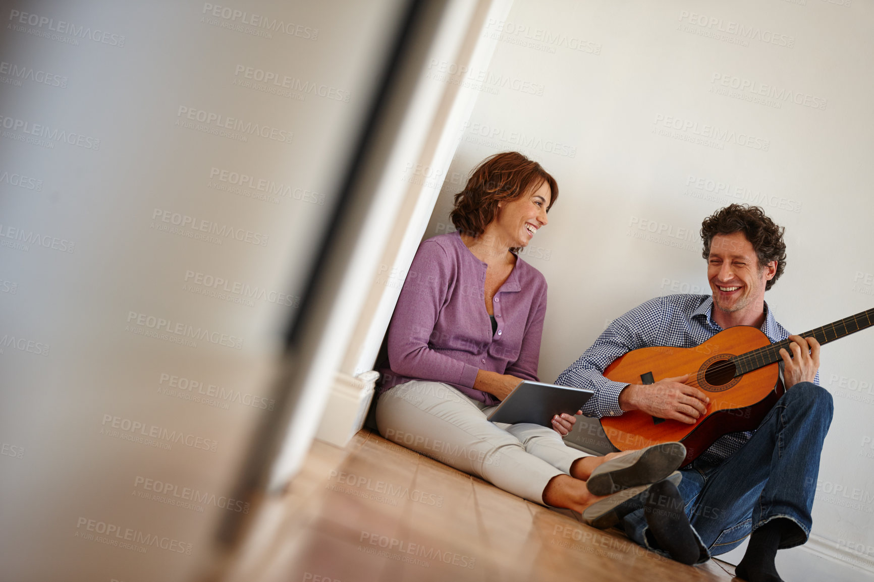 Buy stock photo Support, guitar and couple on floor with tablet, lesson and bonding in home with music and creativity. Musician, man and woman with love, hobby and entertainment together in hallway with tech