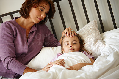 Buy stock photo Shot of a caring mother watching her daughter sleep