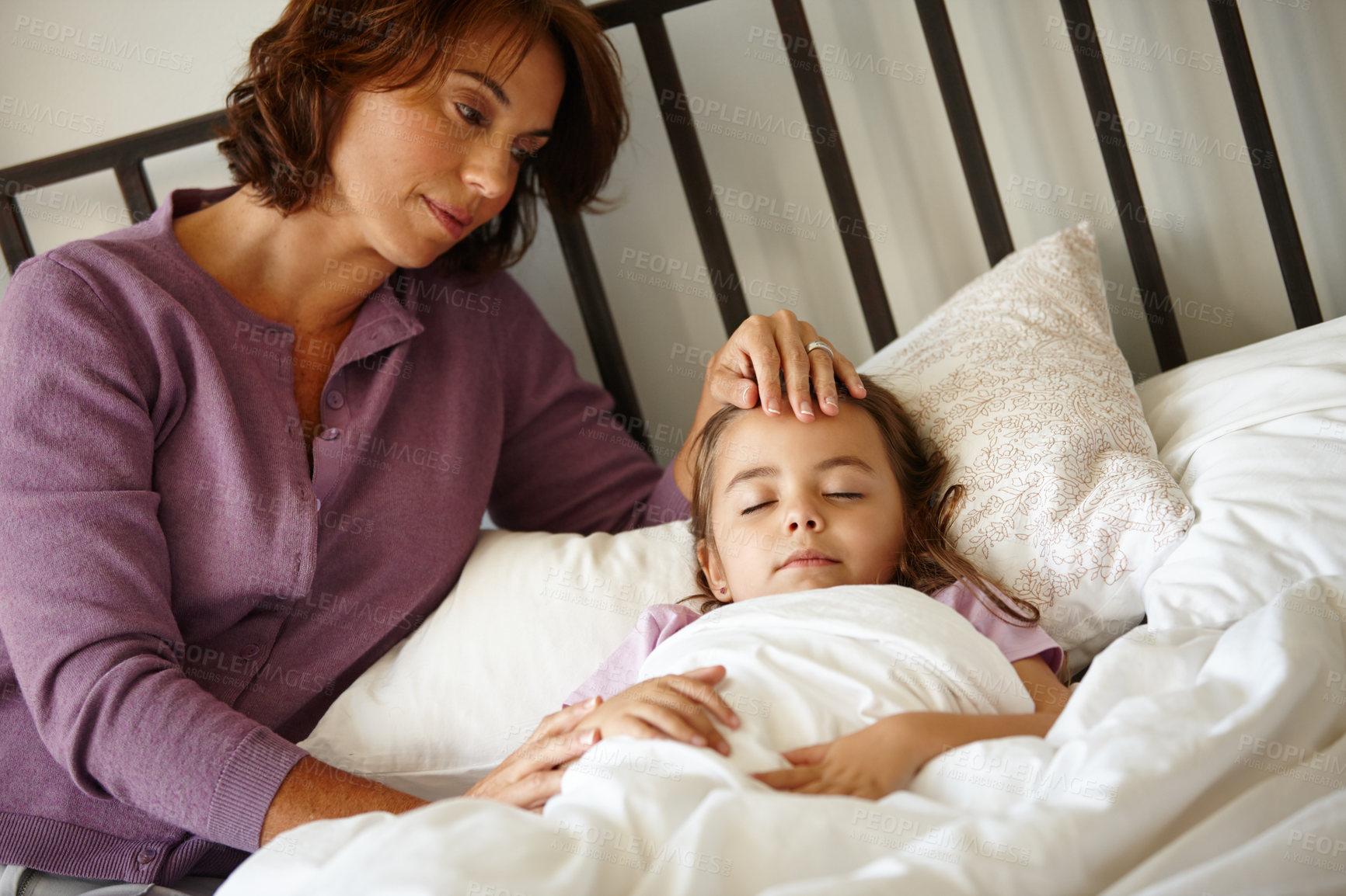 Buy stock photo Shot of a caring mother watching her daughter sleep