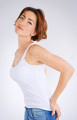 Buy stock photo Studio portrait of a young woman posing against a grey background