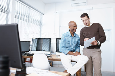 Buy stock photo Two businessmen using a digital tablet in the office