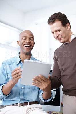 Buy stock photo Two businessmen sharing a digital tablet in the workplace