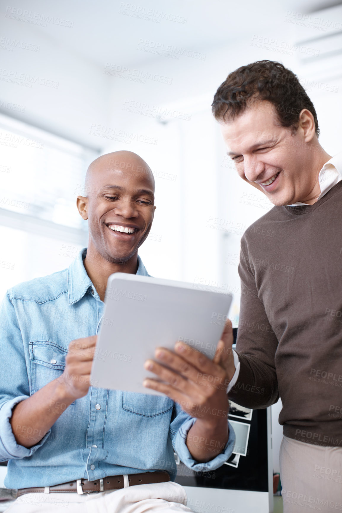 Buy stock photo Two businessmen using a digital tablet in the office