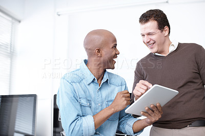 Buy stock photo Two business colleagues sharing a digital tablet in the workplace