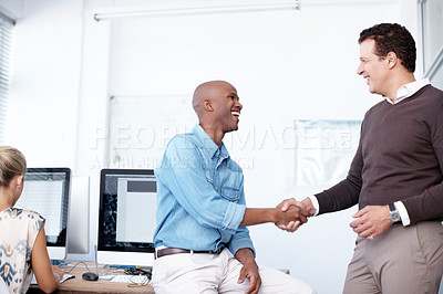 Buy stock photo Two businessmen shaking hands in the workplace