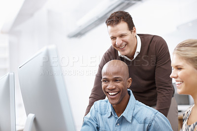 Buy stock photo Two happy colleagues working while their boss looks on