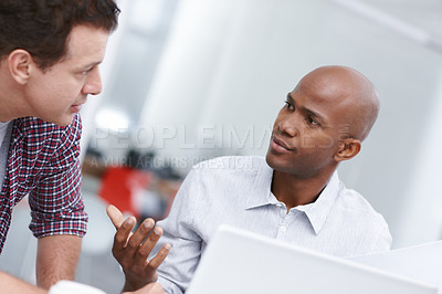 Buy stock photo Two professionals having a work discussion while seated at a desk