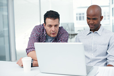 Buy stock photo Two designers working on a project on a laptop while seated at a desk