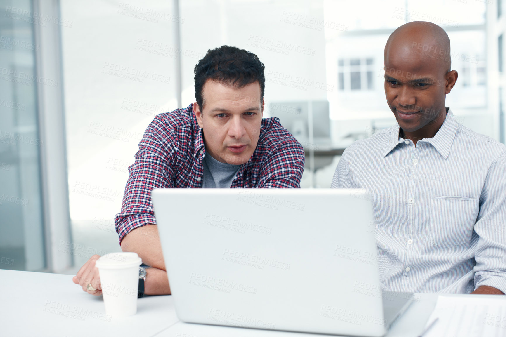 Buy stock photo Two designers working on a project on a laptop while seated at a desk