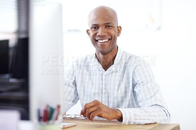 Buy stock photo Portrait of a relaxed-looking african american designer sitting in his chair in front of a desktop computer in the office 